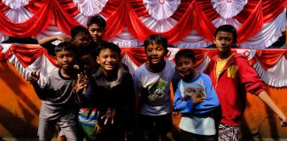 anak anak bergaya di depan atribut merah putih