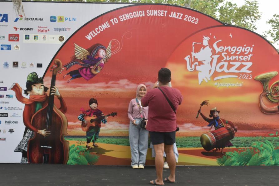 pengunjung mengambil foto di backdrop senggigi jazz festival