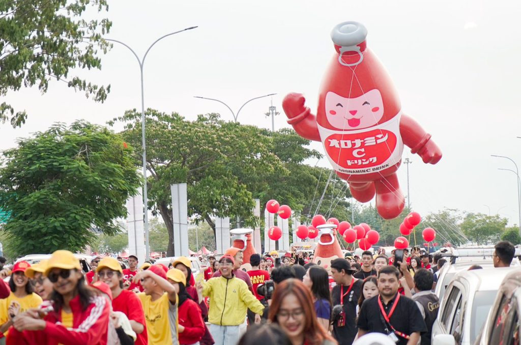 Parade meriah bersama karakter NAMI dan publik figur di Pantai Indah Kapuk, menandai peluncuran kampanye "Your Daily Hero" dari Oronamin C