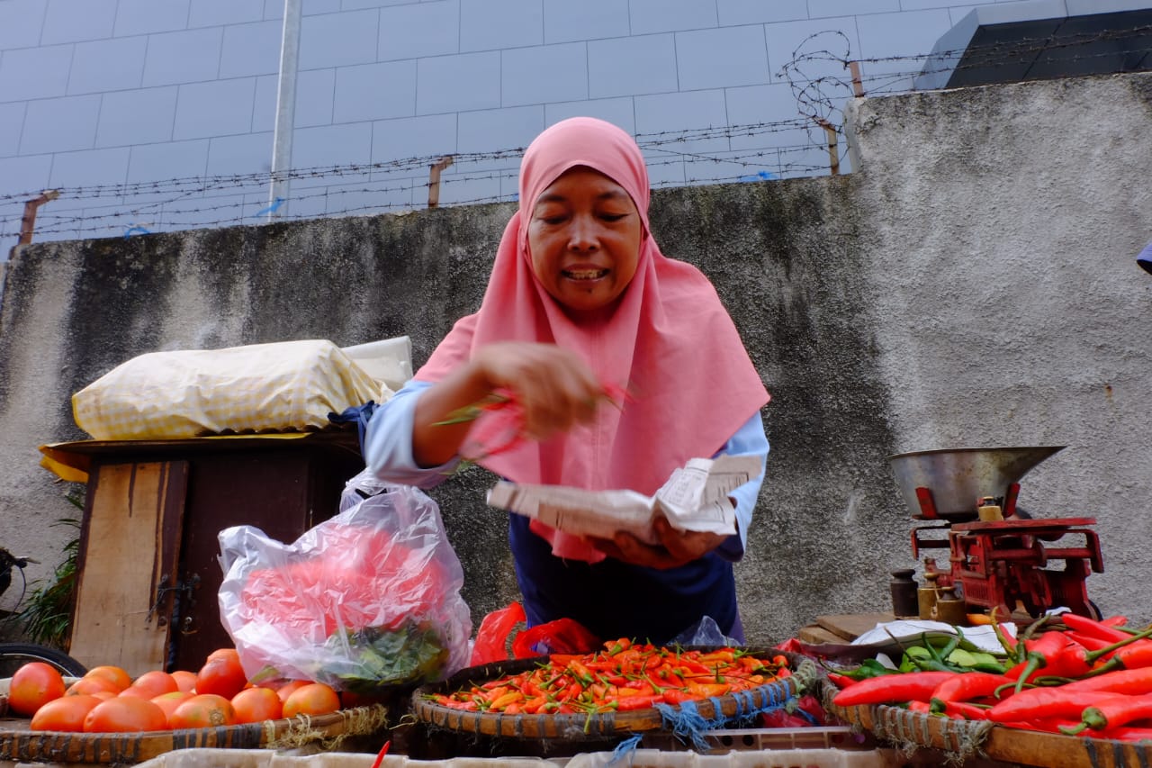 pedagang membungkus cabai dagangannya di pasar palmerah