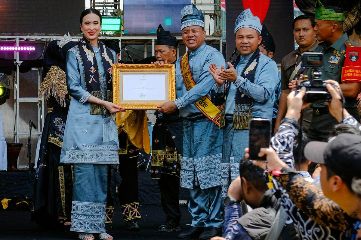 menteri pariwisata, widiyanti putri wardhana menyerahkan sertifikat karisma event nusantara nuntuk acara festival pacu jalur tradisional 2025 di lapangan limuno, riau